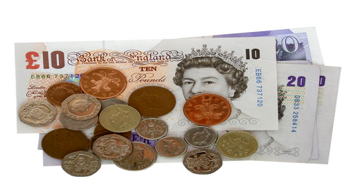 A pile of pound coins on top of notes.