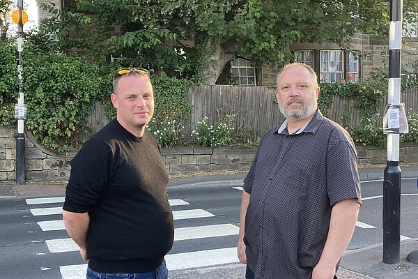 Lib Dem campaigners Marc Hill and Gareth Dibble standing at the crossing outside Pool post office.